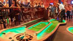 several people are playing mini golf in a bar