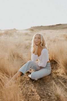 a woman sitting in the middle of a field