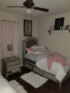 a bed room with a neatly made bed and a ceiling fan