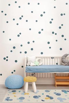 a child's room with blue polka dot decals on the wall