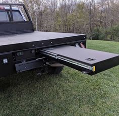 the back end of a pickup truck with its flatbed open and sliding doors opened