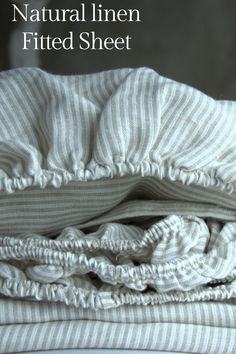 the natural linen fitted sheet is folded on top of each other