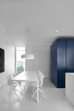 a white table and chairs in a room with blue cupboards on either side of it