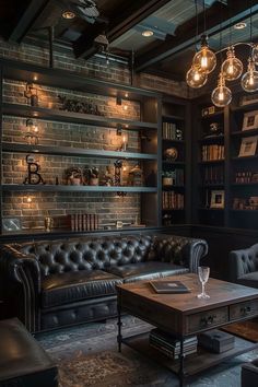 a living room filled with black furniture and lots of bookshelves on the wall