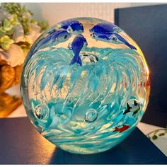 there is a glass bowl with blue and white designs on the inside, sitting on a table