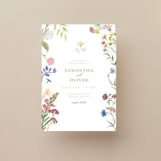 an elegant floral wedding card with the word so written in gold on it and surrounded by wildflowers