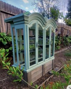 an old china cabinet in the middle of a garden