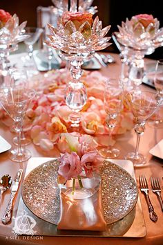 an image of a table setting with pink flowers and champagne glasses on the place settings