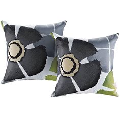 two black and white pillows with an abstract flower on the front, one has green leaves