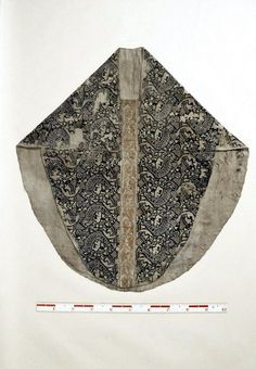 an old piece of cloth with designs on it and tape measure in the foreground