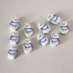 small white and blue buttons with faces on them sitting on a table next to each other