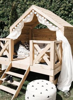 a wooden bed in the shape of a house with stairs leading up to it's roof