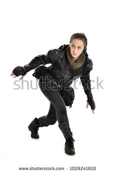 a woman dressed in black is posing for the camera with her arms outstretched and legs spread out