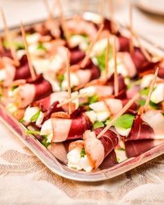 small appetizers with toothpicks are arranged on a platter, ready to be eaten