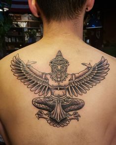 a man with a tattoo on his back is sitting in front of the camera and has an eagle