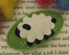 a felt brooch with a sheep face on it