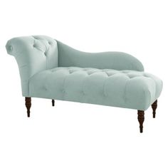 a light blue chaise lounger with wooden legs and tufted upholster