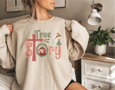 "The Jesus Christmas sweatshirt with the words \"true story\" and a beautiful Christmas nativity graphic is the perfect addition to your cozy wardrobe during the holiday season. This sweatshirt is not only stylish but it also carries a powerful message reminding us of the true reason for the holiday season- the birth of Christ.  This sweatshirt is perfect for any day during the holiday season and is great for both indoor and outdoor activities. Whether you're attending a Christmas party or enjoying a cozy night in with your loved ones, this sweatshirt is sure to keep you warm and comfortable. In conclusion, the Jesus Christmas sweatshirt with the \"true story\" message and nativity graphic is a cozy and stylish way to celebrate the birth of Christ and spread the message of the true meaning Nativity Scene Sweatshirt, Cozy Wardrobe, Birth Of Christ, Jesus Sweatshirts, Jesus Christmas, The Birth Of Christ, Christmas Jesus, Jesus Shirt, True Meaning Of Christmas