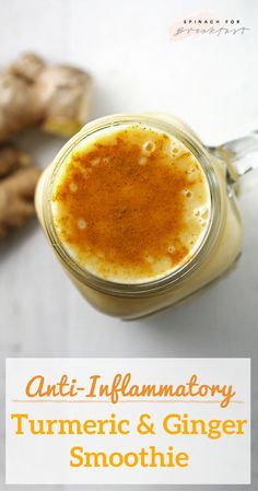 an orange and ginger smoothie in a glass jar next to sliced ginger on a white surface