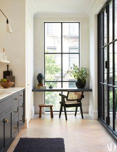 a room that has a chair and some plants on the table in front of it