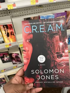 a person holding up a book in a store