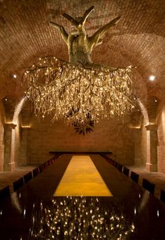 a chandelier hanging from the ceiling in a room with columns and lights on it