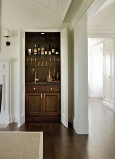 an open door leading into a kitchen with wooden floors and cabinets on the wall above it