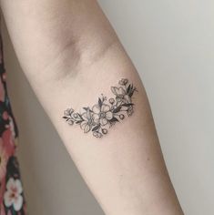 a woman's arm with a flower tattoo on the left side of her arm