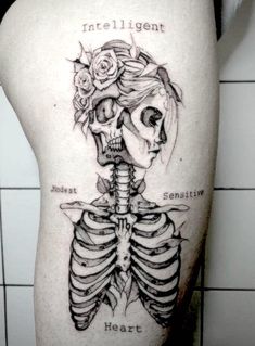 a woman's thigh with a skeleton and roses tattoo on the side of her leg