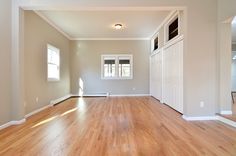 an empty living room with hard wood flooring and white trim on the walls,