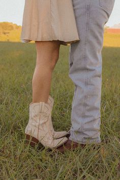 a man and woman standing next to each other in the grass