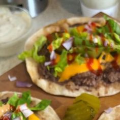 three pita breads with different toppings on them sitting on a cutting board