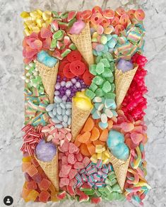 an ice cream cone filled with gummy bears and other candies on top of a marble surface