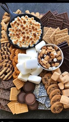 a platter filled with crackers, marshmallows, and other snacks