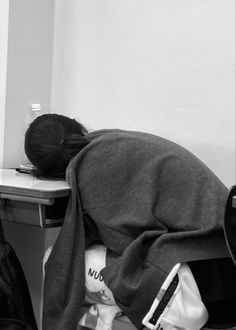 a person sitting at a desk with their head under a blanket