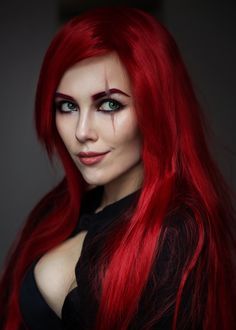 a woman with long red hair and green eyes is posing for the camera, wearing black