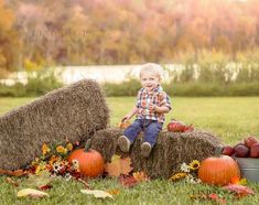 a little boy sitting on hay bales with pumpkins