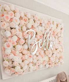 a baby's room decorated with flowers and a name sign above the crib