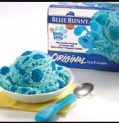 blue bunny ice cream is in a bowl and next to it's box with spoons