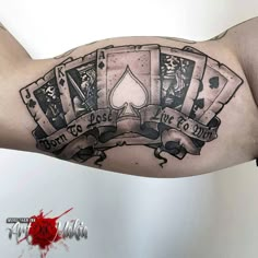 a man's arm with playing cards tattoo on it