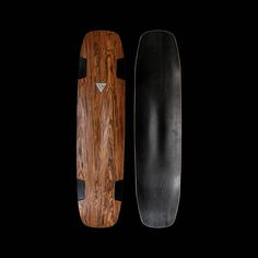 two wooden skateboards side by side on a black background, one has a long board in the middle