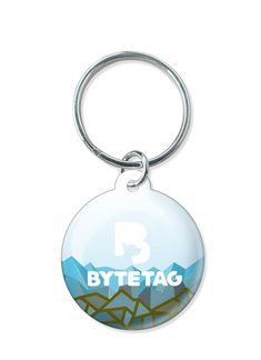 a round keychain with the word byte tag on it and mountains in the background