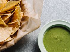 a bowl of guacamole next to some tortilla chips