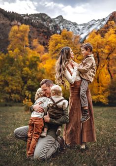 a family poses for a photo in the mountains