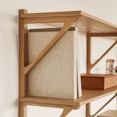 a wooden shelf with a book on it and some bookshelves in the background