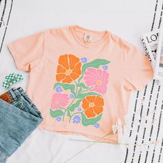 Looking for a cute versatile top to wear? Make sure to grab one of our Graphic Tees! This soft and comfortable graphic Tee is the perfect top for any outfit. It can be paired with biker shorts, jeans, or even a simple skirt/dress! This Tee is true-to-size, so be sure to order your regular t-shirt size! If you are looking for a more oversized look, make sure to size up! Cute Peach T-shirt With Crew Neck, Spring Cotton Crop Top T-shirt, Pink Retro Printed T-shirt, Peach Crew Neck Top With Graphic Print, Trendy Orange Short Sleeve Crop Top, Pink Relaxed Fit Crop Top With Crew Neck, Trendy Heather Peach Crew Neck Top, Cute Spring Tops With Screen Print, Spring Peach Graphic Print T-shirt