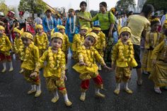 children dressed in yellow are walking down the street