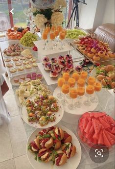 a table filled with lots of food on top of plates and glasses next to each other