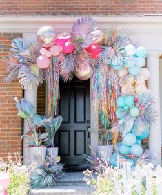 an entrance decorated with balloons and palm leaves