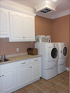 a washer and dryer sitting in a kitchen next to each other on top of cabinets